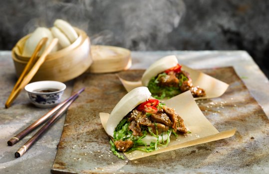 Food photograph of a steamed bar filled with shredded hoisin duck, fresh chilli and shredded lettuce