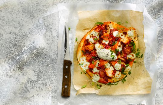 Aerial food photograph of a lobster and nduja topped flatbread with a quenelle of mascarpone cream in the centre